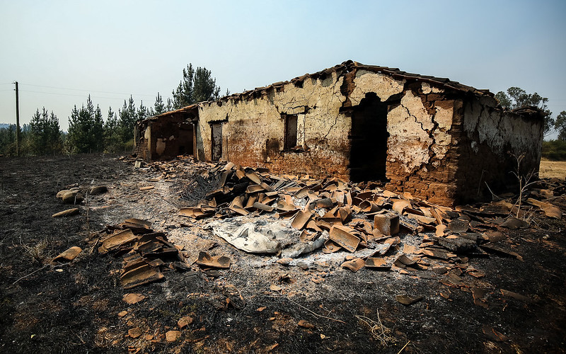 This photo shows a destroyed house with rubble in front of it
