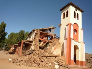 This photo shows a destroyed house next to an intact tower